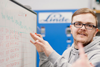 Student schreibt etwas auf die Tafel