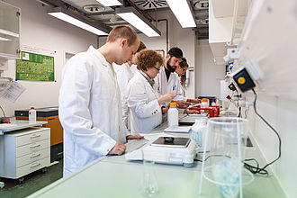 Studierende beim Experimentieren im Laborbank 