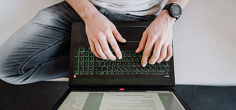 Hände tippen auf einer Laptop-Tastatur